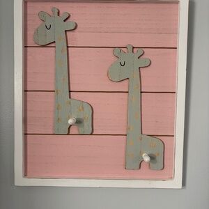 Adorable giraffe wooden distressed wall decor with knobs to hang items.